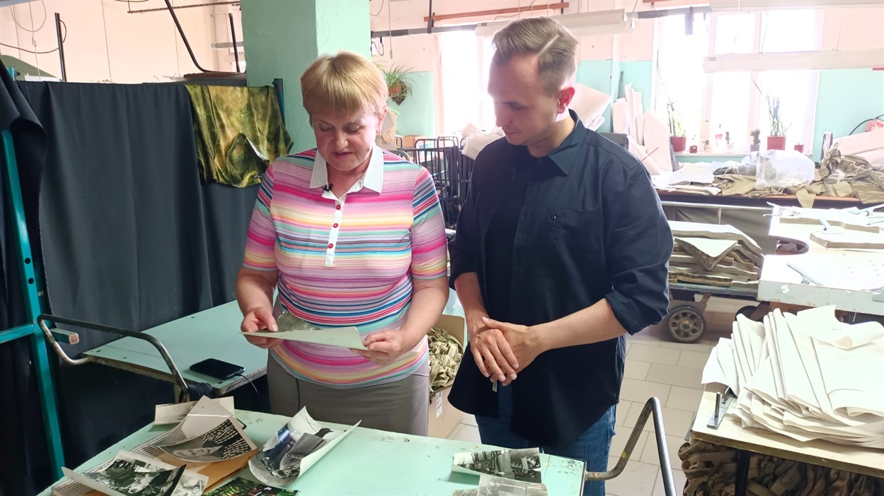 Марія Леонідівна показує Олександру Олеговичу, керівнику фабрики, старі фото